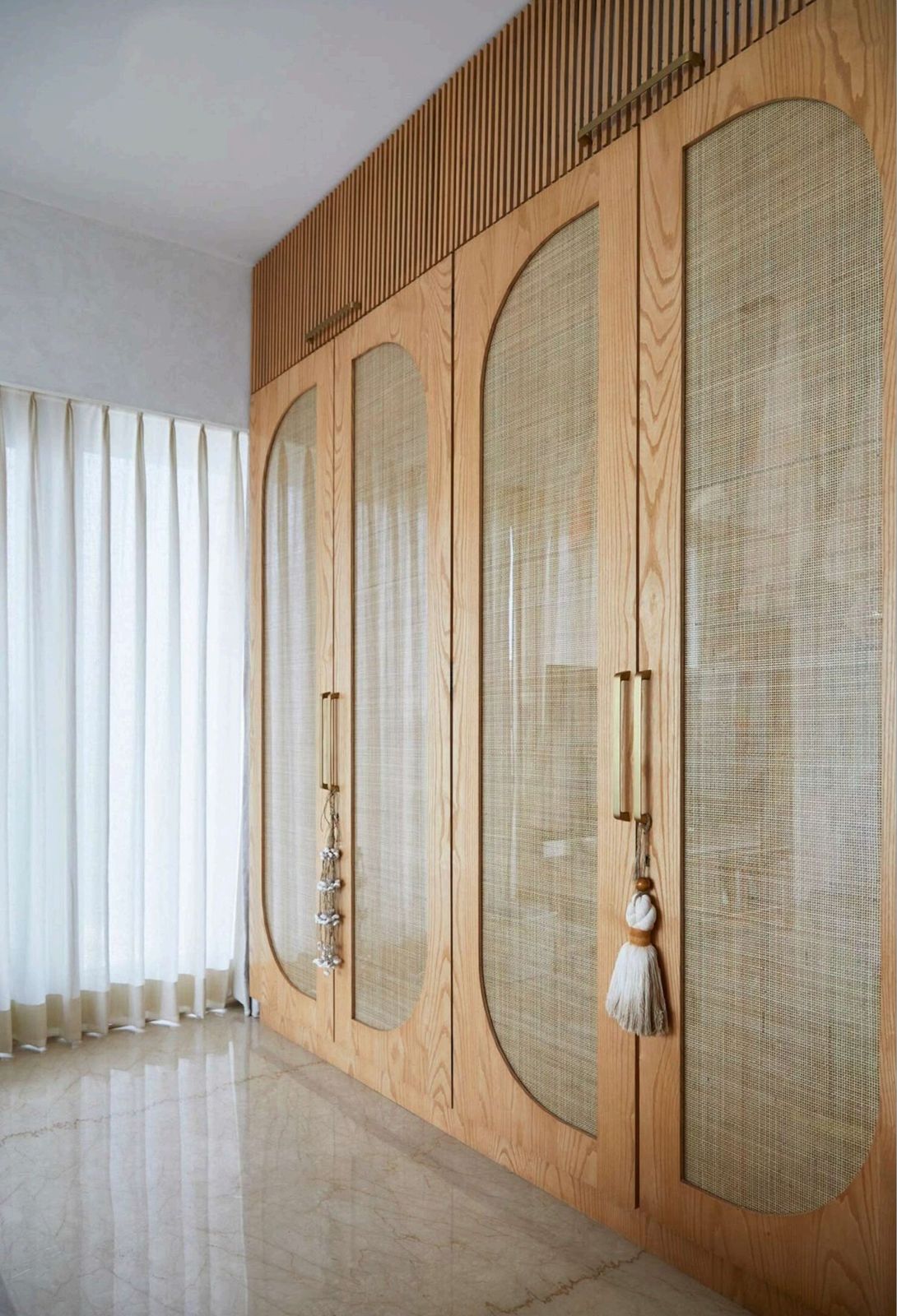 Modern bedroom wardrobe design with cane and laminate finish by ModuCrafts